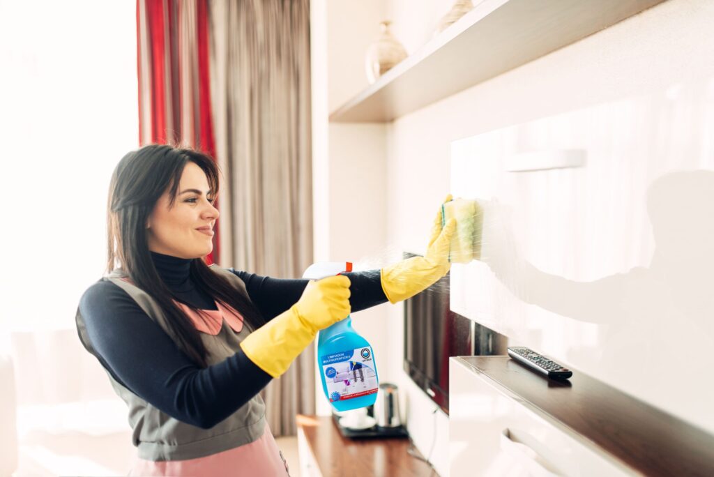 Copia de housemaid cleans furniture with a cleaning spray OPTIMUM